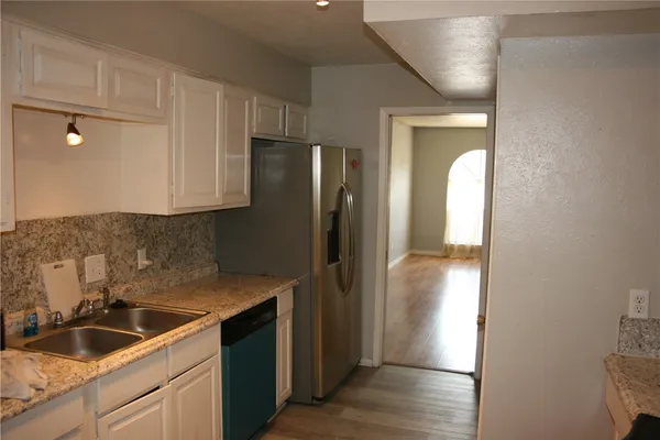a kitchen with a refrigerator and a sink