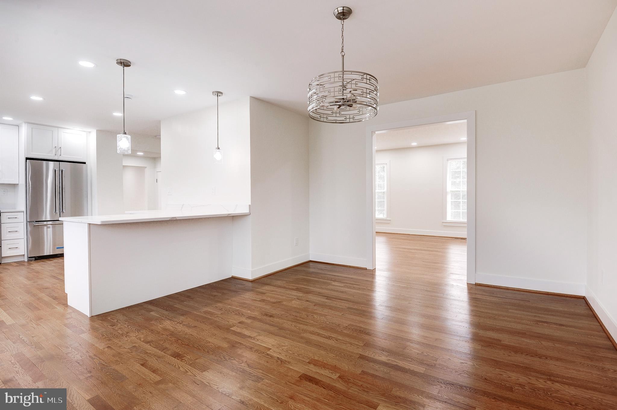 9704 Hall Road Potomac, MD 20854 - Photo 14 of 61 wooden floor in an empty room with a kitchen