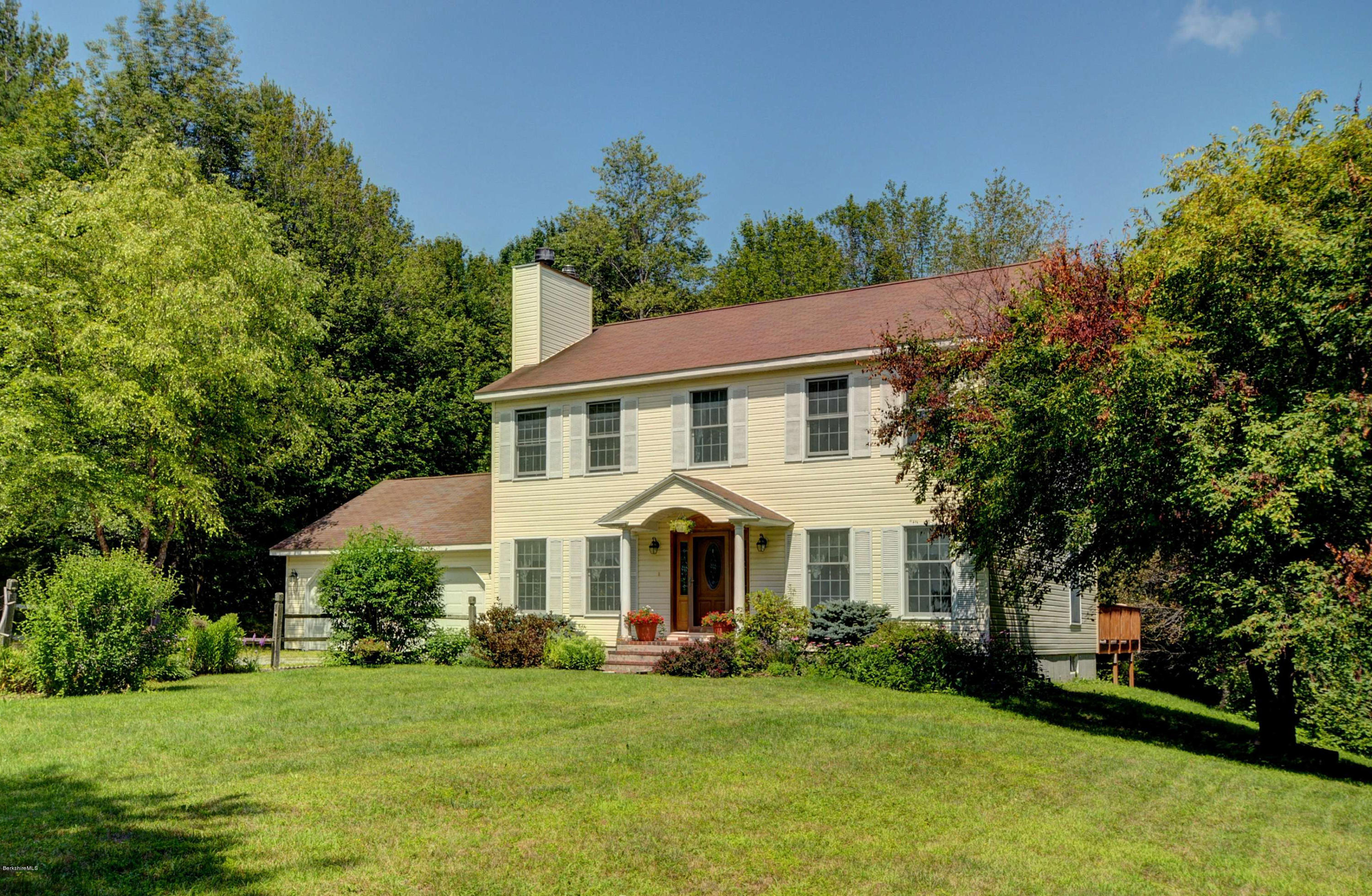a view of a house with garden and trees