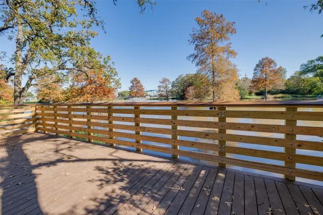 a view of a balcony with wooden floor and fence