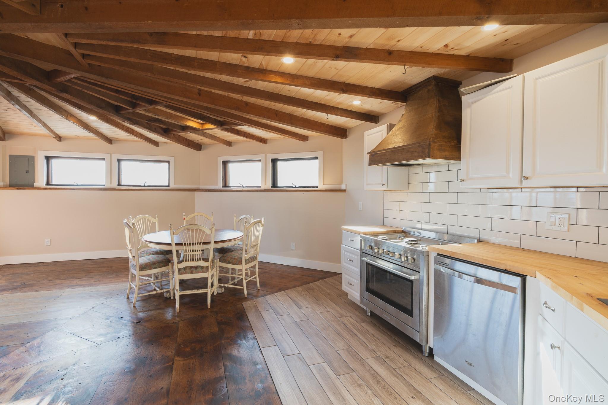 15 Deans Road Napanoch, NY 12458 - Photo 3 of 21 Kitchen featuring butcher block counters, custom exhaust hood, white cabinets, stainless steel appliances, and a wooden ceiling with exposed beams