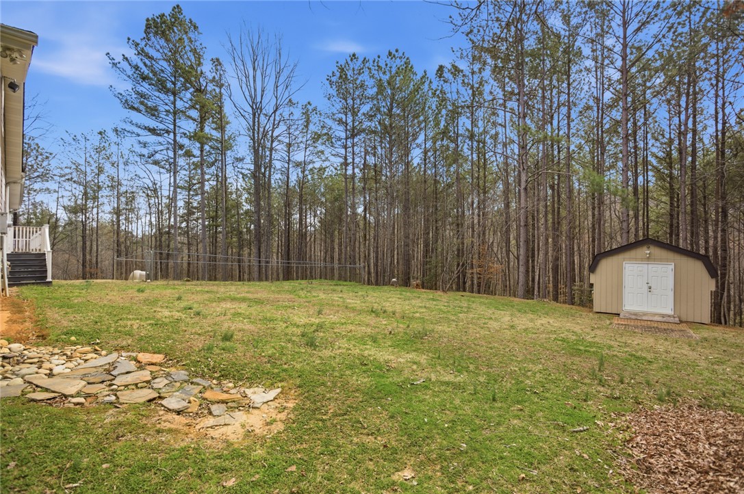 196 Flyroot Trail Pickens, SC 29671 - Photo 40 of 48 A spacious backyard with mature trees and a functional storage shed.