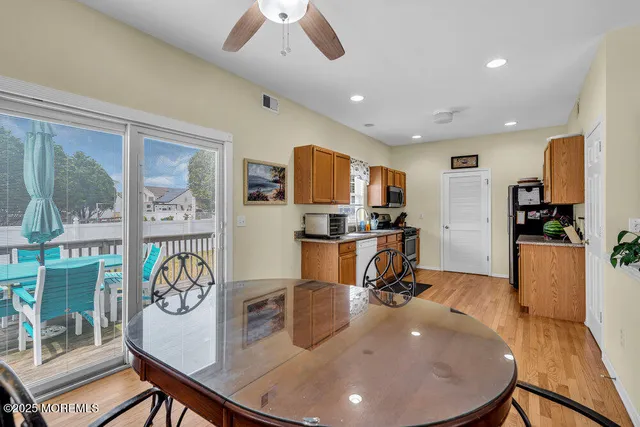 a view of a dining room with furniture a kitchen and chandelier