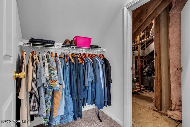 a view of walk in closet with clothes