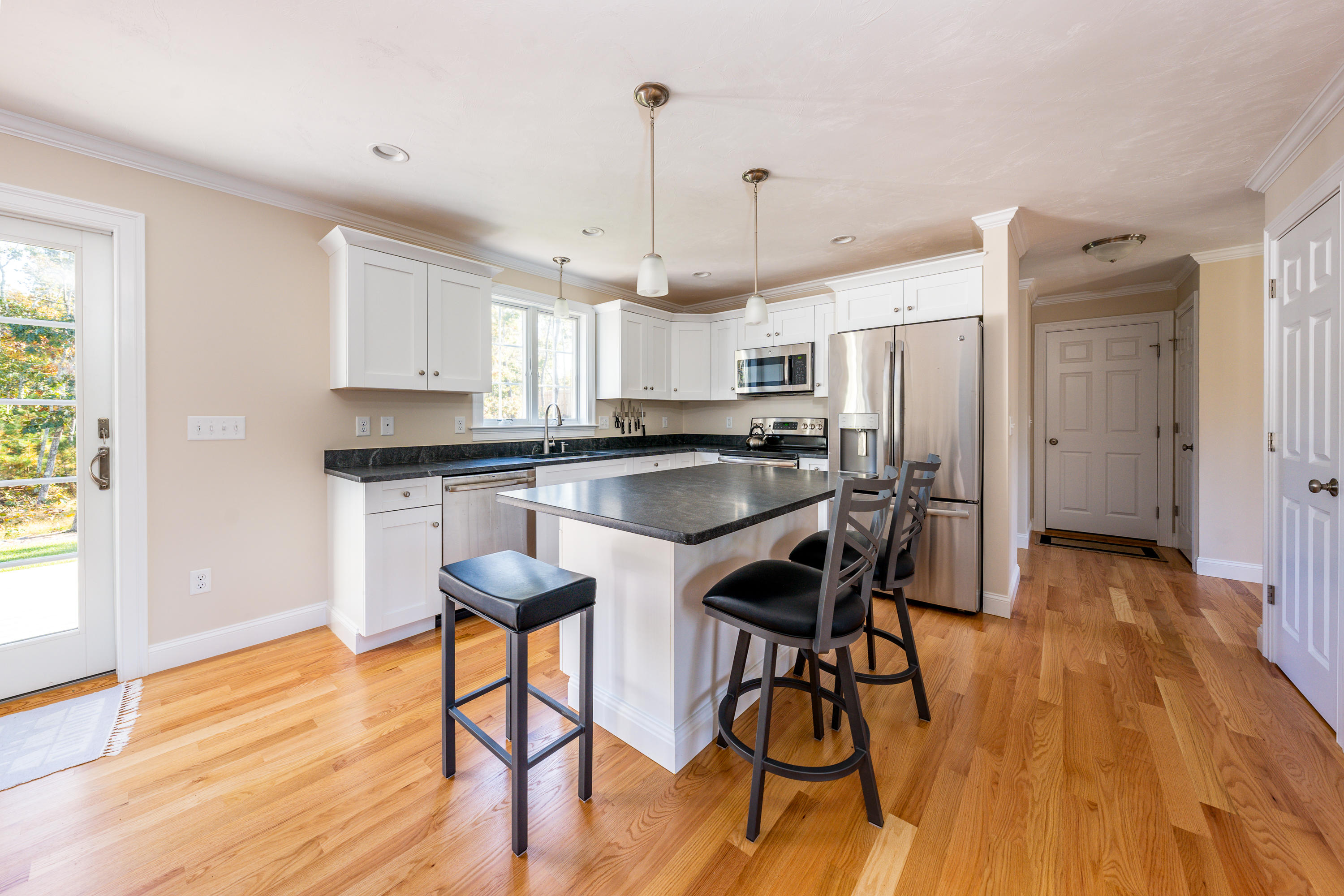 297 Depot Road Harwich, MA 02645 - Photo 6 of 22 a kitchen with stainless steel appliances a table chairs refrigerator and wooden floor