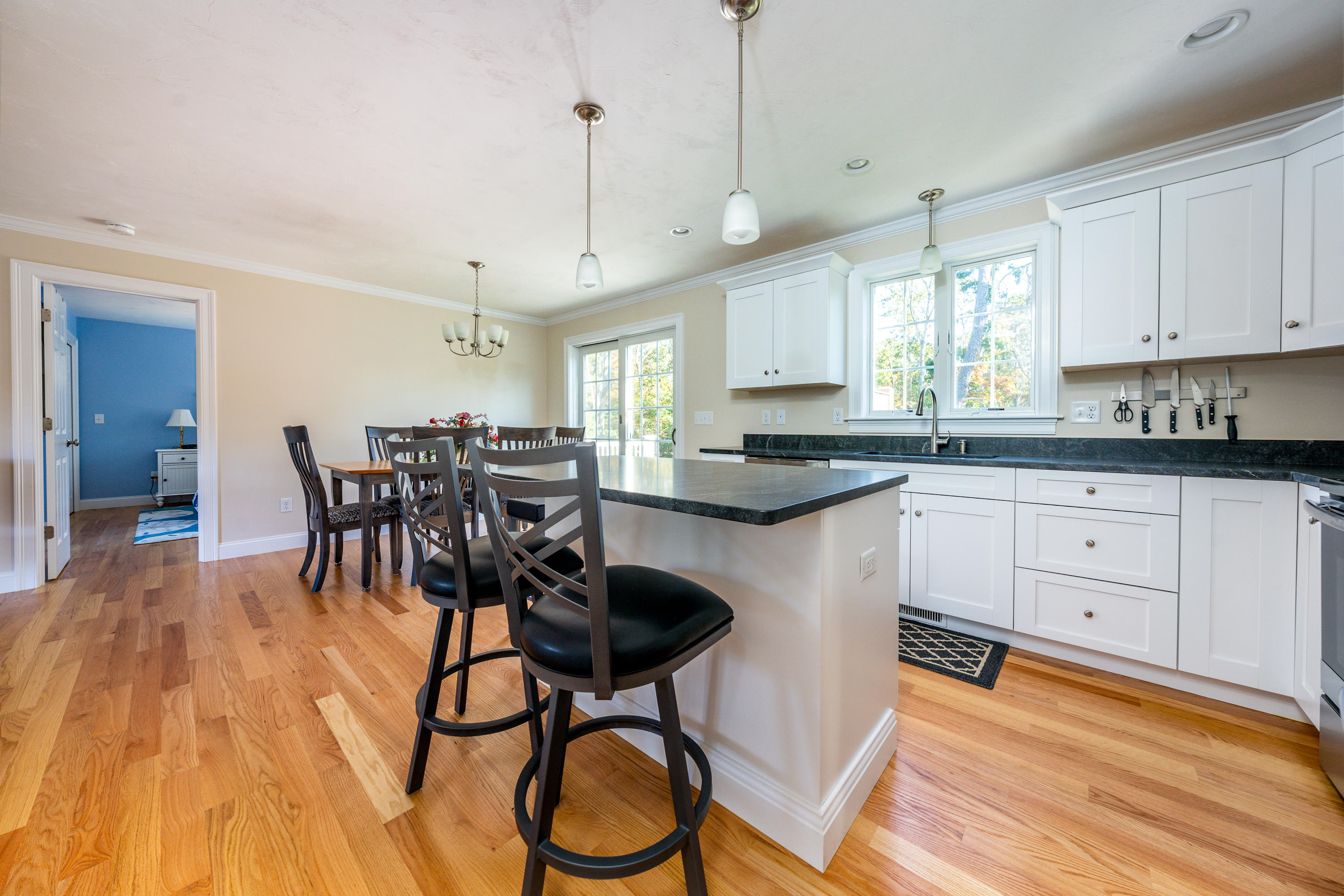 297 Depot Road Harwich, MA 02645 - Photo 7 of 22 a kitchen with stainless steel appliances granite countertop a stove a sink a dining table and chairs with wooden floor