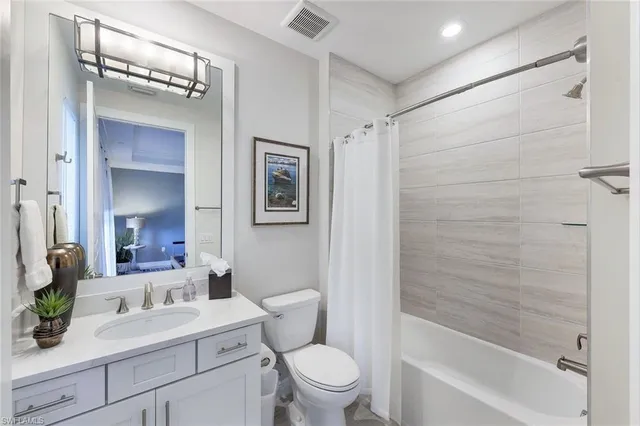 a bathroom with a sink a toilet a mirror a vanity and shower