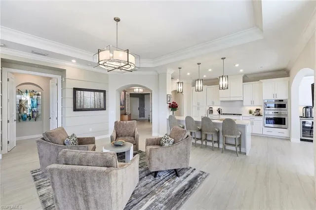 a living room with furniture dining table and a chandelier