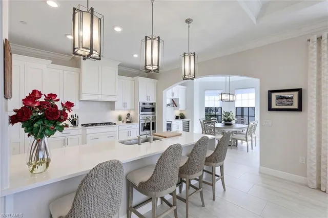 a kitchen with stainless steel appliances kitchen island granite countertop a dining table chairs and granite counter tops