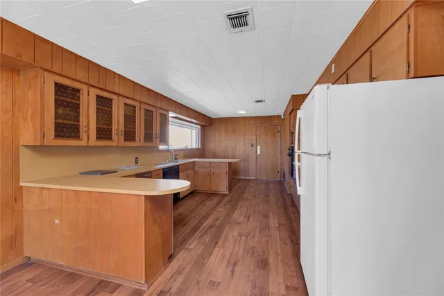 a kitchen with a sink and wooden floor