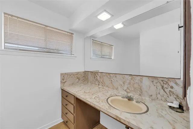 a bathroom with a granite countertop sink and a mirror