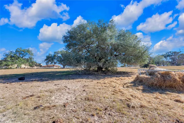 a view of a yard with wooden fence