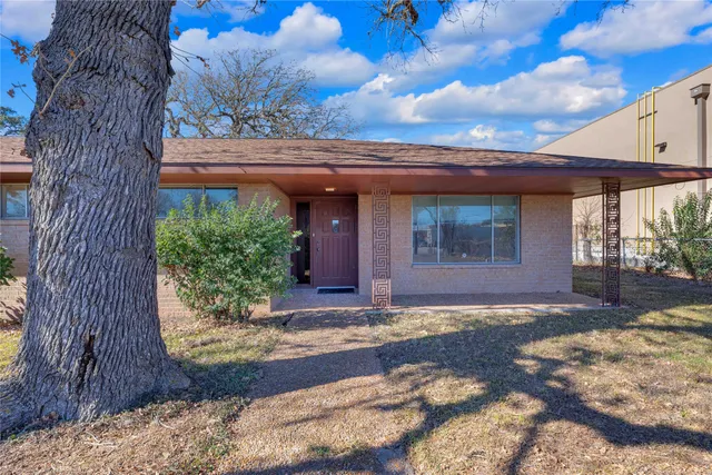 a view of a house with a tree in front of it