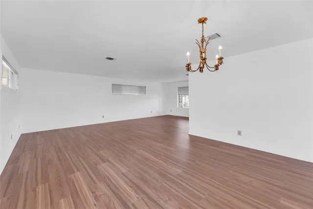 a view of a room with wooden floor and white walls