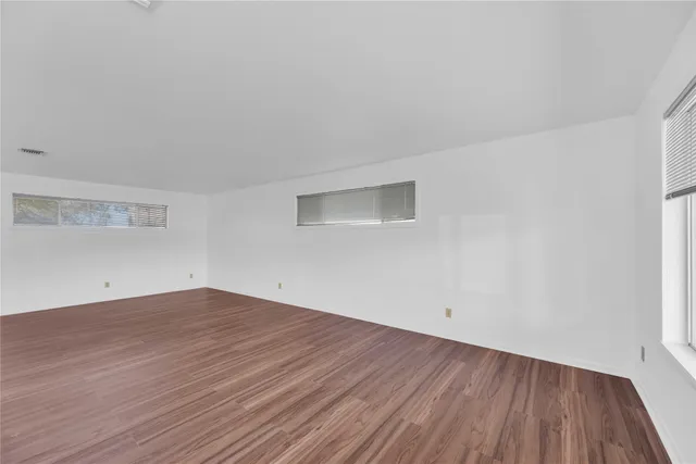 a view of a room with wooden floor and white walls