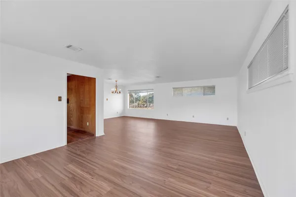 an empty room with wooden floor and closet