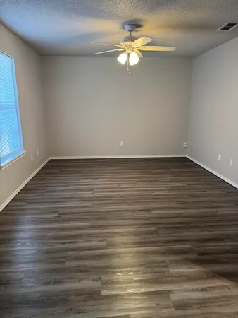 a view of a room with wooden floor and ceiling fan