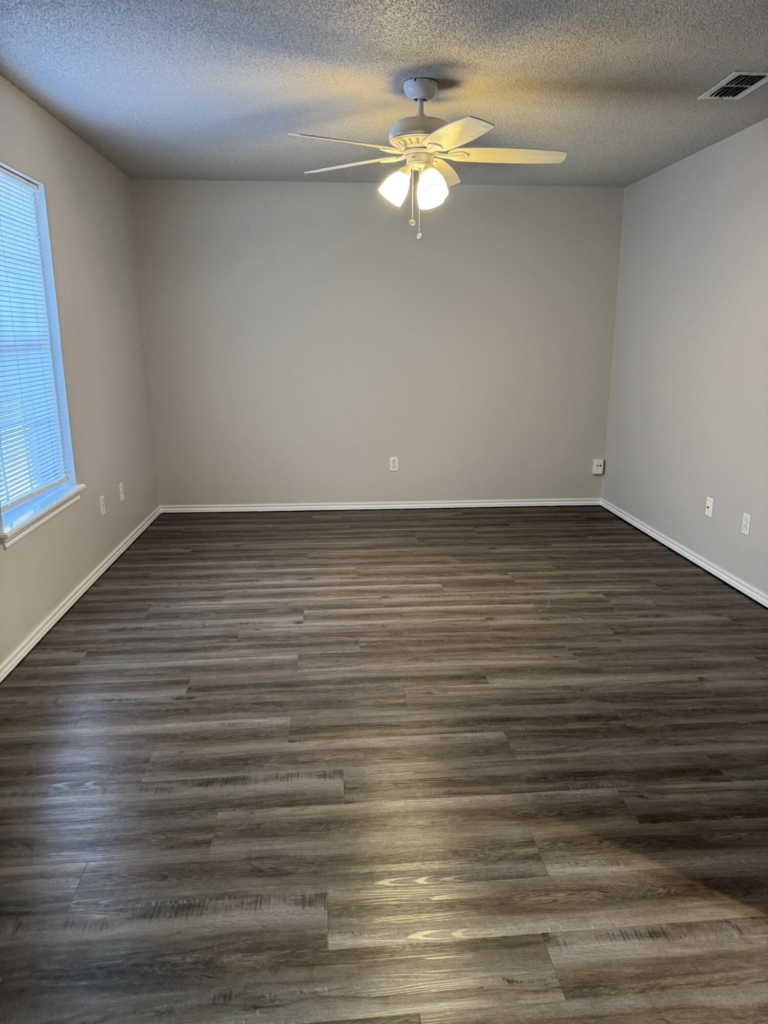 209 Grover Avenue Lubbock, TX 79416 - Photo 14 of 19 a view of a room with wooden floor and ceiling fan