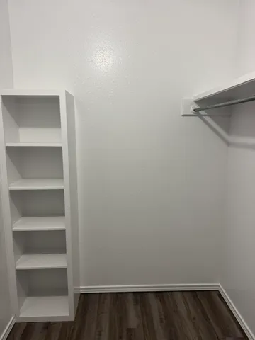 a view of walk in closet with empty racks