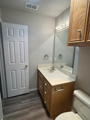 a bathroom with a sink vanity mirror and toilet