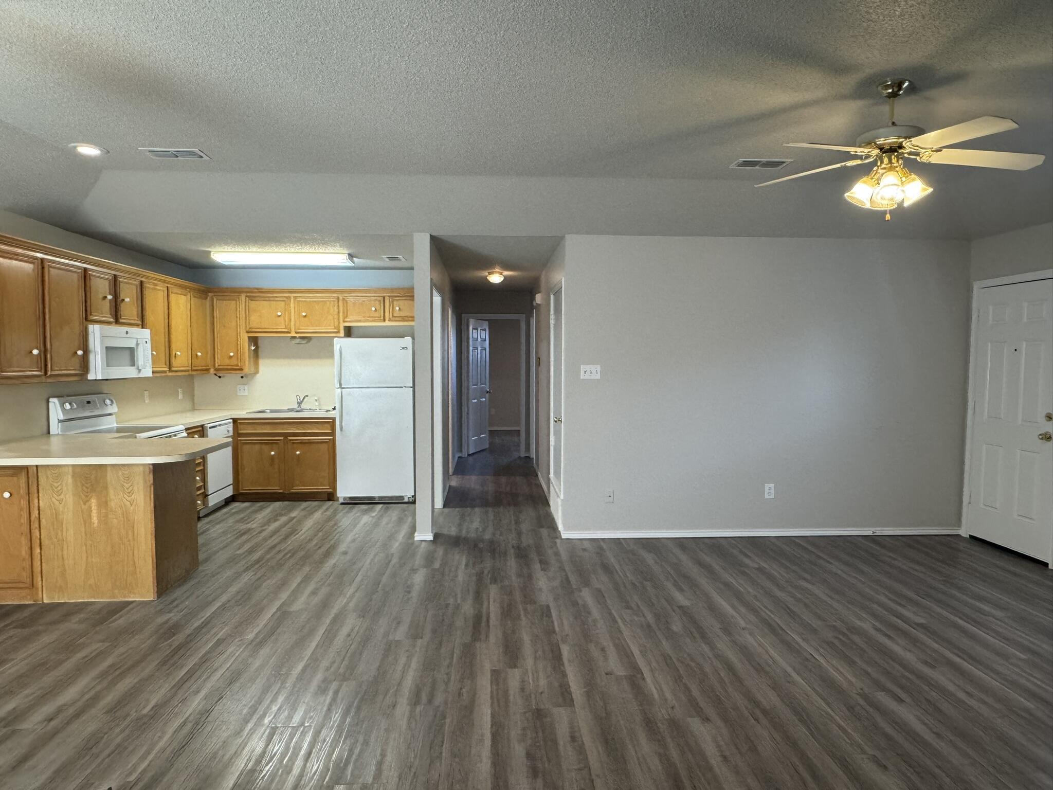 209 Grover Avenue Lubbock, TX 79416 - Photo 7 of 19 a view of a kitchen with a sink and dishwasher a refrigerator with wooden floor