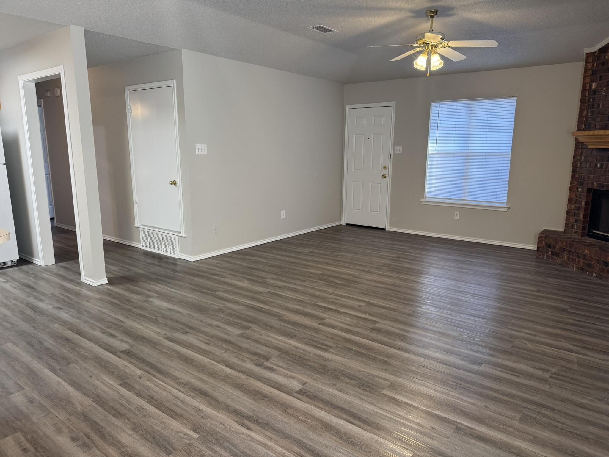 209 Grover Avenue Lubbock, TX 79416 - Photo 8 of 19 an empty room with wooden floor and windows