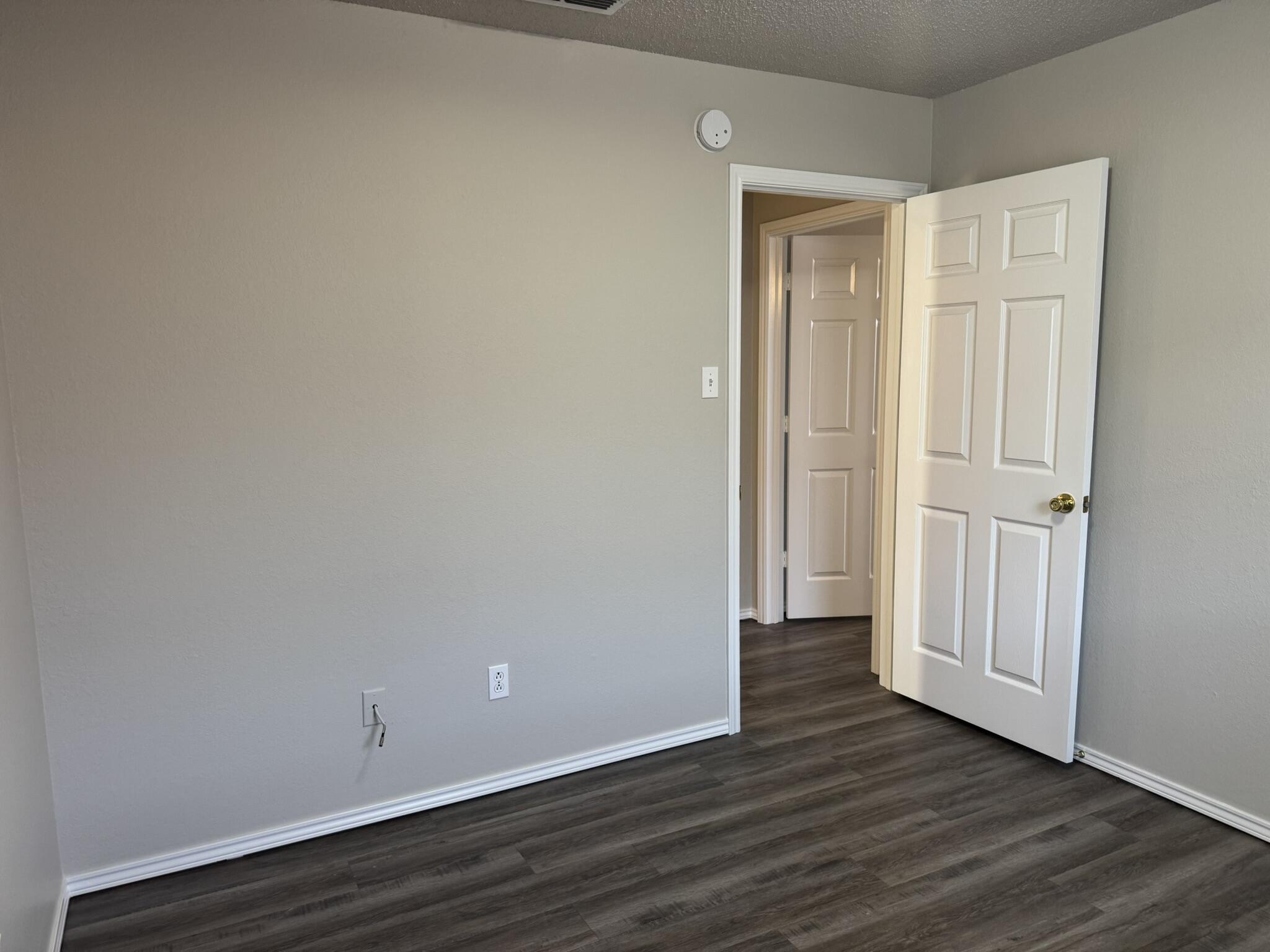 209 Grover Avenue Lubbock, TX 79416 - Photo 10 of 19 a view of an empty room with wooden floor