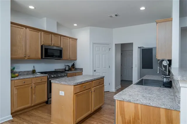 a kitchen with stainless steel appliances granite countertop sink stove and refrigerator