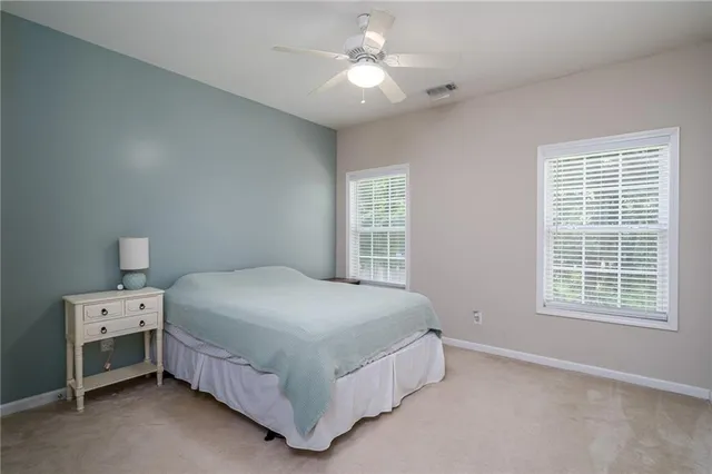 a bedroom with a bed and a chandelier fan