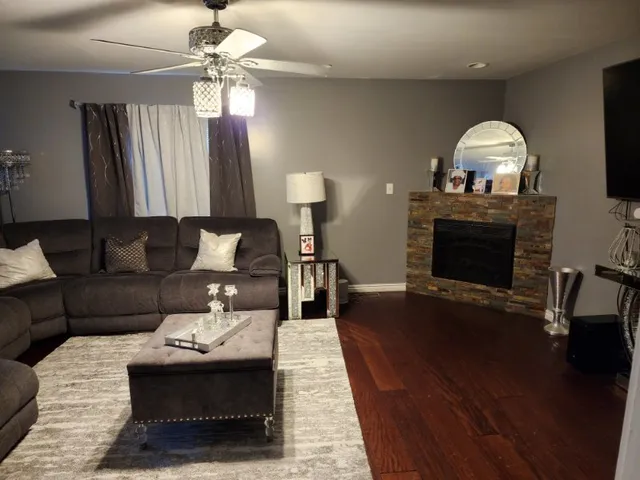 a living room with furniture a fireplace and a chandelier