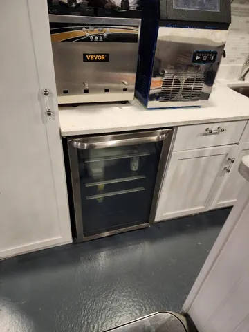 a room with granite countertop a sink a stove and chairs