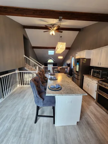 a view of a kitchen with a dining table and chairs