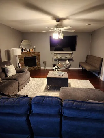 a living room with furniture a flat screen tv and a fireplace