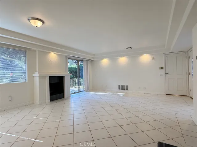 an empty room with fireplace and windows