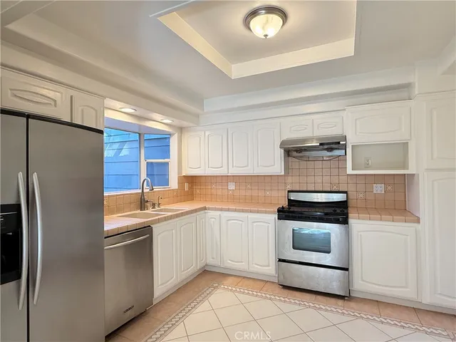 a kitchen with granite countertop stainless steel appliances and white cabinets