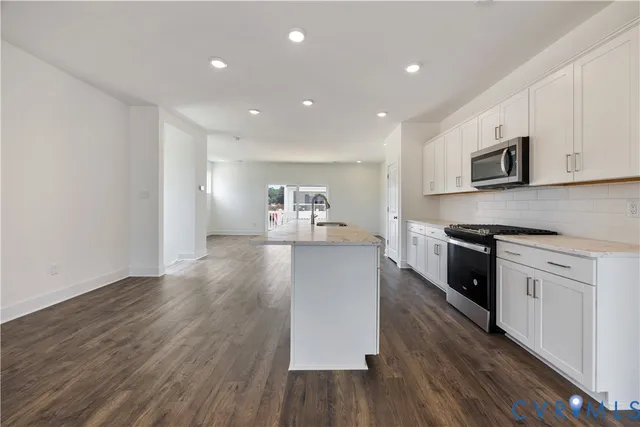a large kitchen with cabinets wooden floor and stainless steel appliances