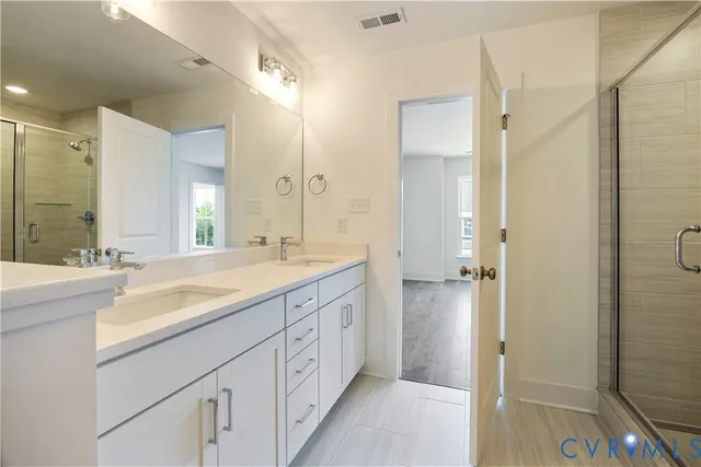 a spacious bathroom with a shower sink and mirror