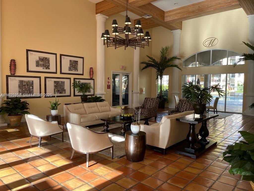 160 Southwest 117th Terrace, Unit 6106 Pembroke Pines, FL 33025 - Photo 15 of 28 a living room with couches a chandelier and a dining table with wooden floor