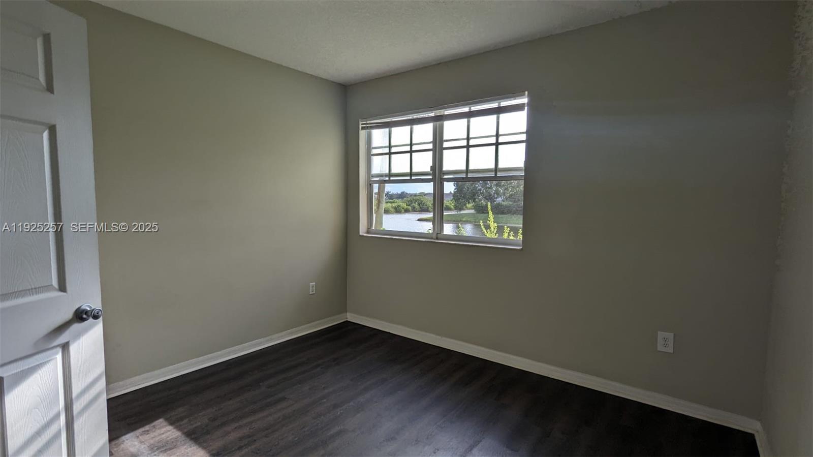 160 Southwest 117th Terrace, Unit 6106 Pembroke Pines, FL 33025 - Photo 5 of 28 an empty room with wooden floor and windows