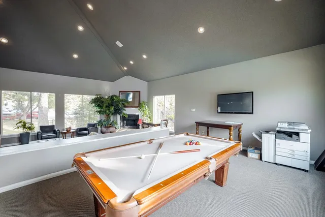 a living room with game table furniture and a large window