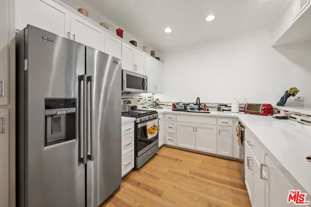 a kitchen with stainless steel appliances a refrigerator sink and microwave