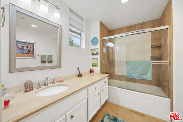 a bathroom with a granite countertop sink mirror bathtub and shower