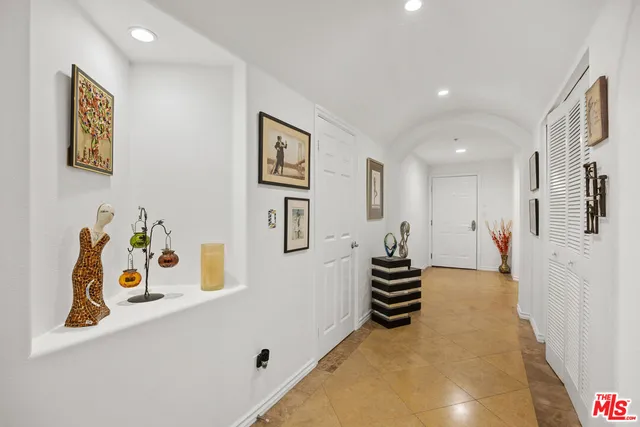 a hallway with a white stove and white cabinets