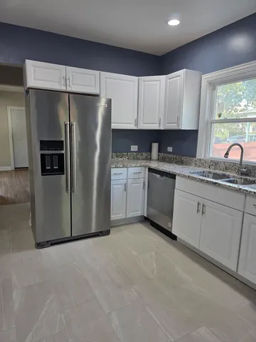 a kitchen with stainless steel appliances granite countertop a refrigerator sink and cabinets
