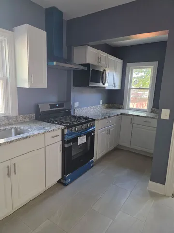 a kitchen with stainless steel appliances granite countertop a sink stove and cabinets