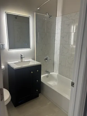 a bathroom with a bathtub sink vanity and toilet
