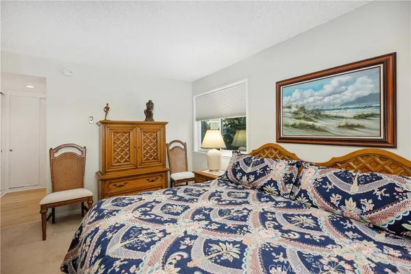 a bedroom with furniture and a painting on the wall