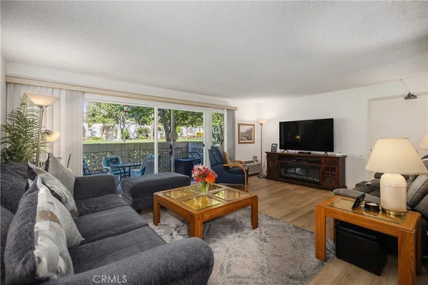 a living room with furniture a flat screen tv and a large window