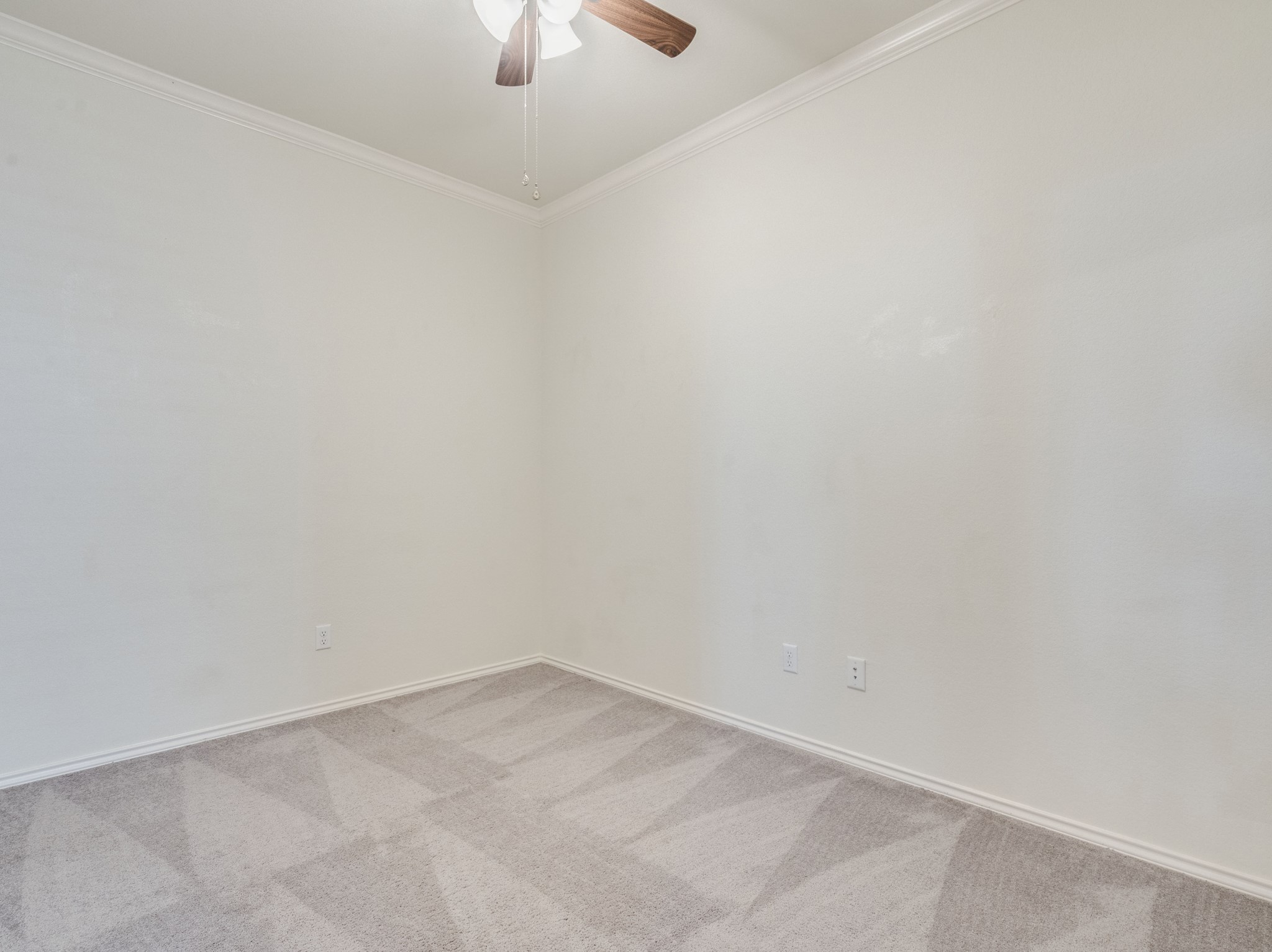 790 Pepperbark Loop Buda, TX 78610 - Photo 17 of 22 A well-lit bedroom awaits personalization, featuring comfortable carpet and a practical ceiling fan for year-round comfort.