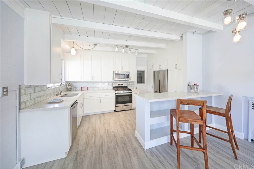 145 Avenida Mateo San Clemente, CA 92672 - Photo 3 of 10 a kitchen with white cabinets and stainless steel appliances